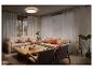Salon confortable avec canapés beiges, coussins orange et table en bois, éclairé par un plafonnier.