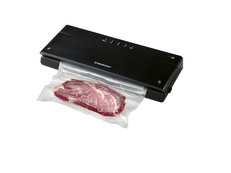 Appareil de mise sous vide avec du bœuf cru dans un sac sous vide.