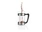 Du café moulu versé dans une cafetière à piston en verre.