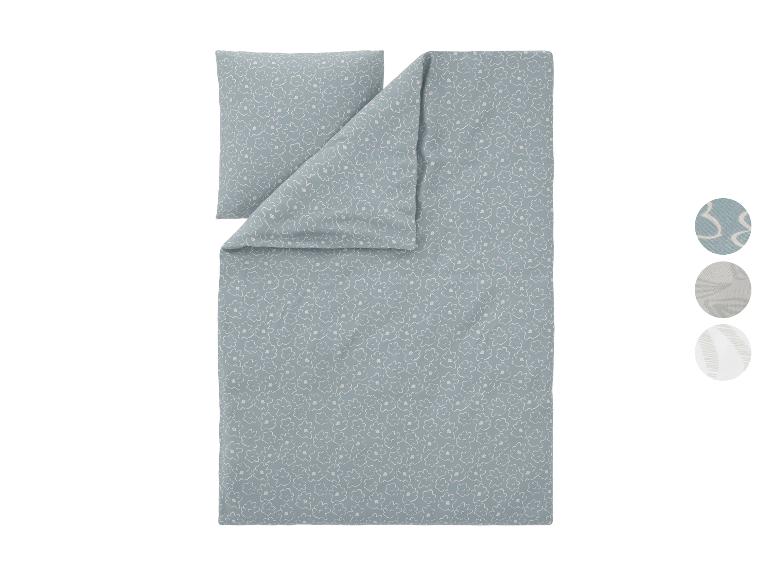 Housse de couette bleue à motif floral blanc et oreiller assorti, avec échantillons de tissu.