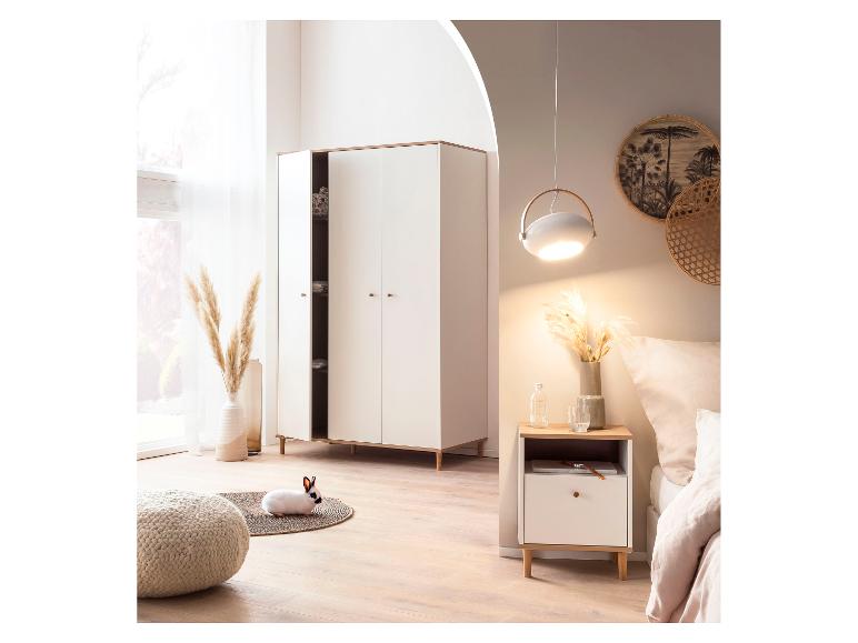 Chambre à coucher avec armoire blanche, table de chevet, lit et un lapin sur un tapis.