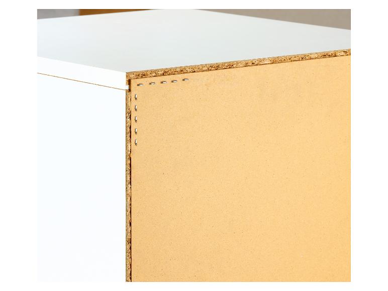Bord de panneau de particules avec des agrafes le fixant à une étagère blanche.