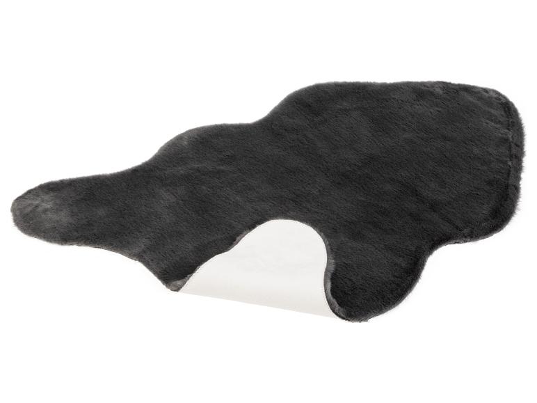 Un tapis en fausse fourrure gris en forme de nuage.