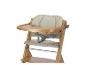 Chaise haute en bois avec un siège rembourré beige clair et un harnais de sécurité.