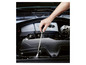 Une main utilisant une lampe torche magnétique pour inspecter le moteur d'une voiture.