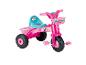 Un tricycle Barbie rose avec un panier et des pneus larges.