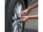 Une personne utilise une clé dynamométrique et une douille pour serrer un écrou de roue sur une voiture.