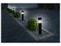 Des lampes extérieures noires le long d'une allée pavée.