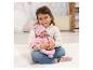 Fille tenant une poupée bébé en tenue rose, assise sur un tapis blanc.