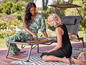 Deux femmes jouent à un jeu de société sur une terrasse avec une chaise longue
