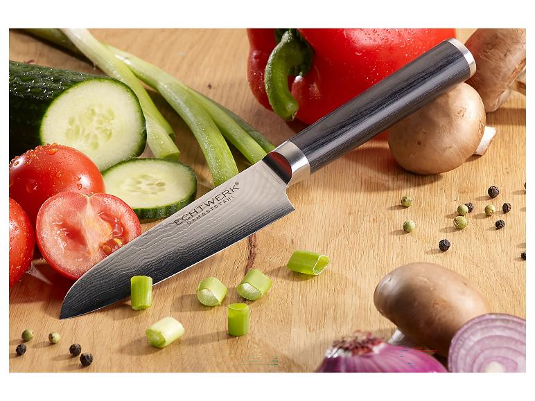 Couteau Santoku en acier damas ECHTWERK sur une planche à découper en bois avec des légumes frais.