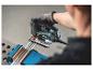 Homme utilisant une scie sauteuse Metabo pour couper un profilé en aluminium.