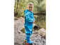 Un enfant portant une salopette et des bottes de pluie bleues.