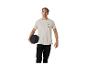 Homme en t-shirt beige clair avec symboles noirs et pantalon noir, tenant un ballon noir.