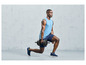 Un homme fait des squats avec une haltère pendant un entraînement.
