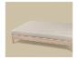 Matelas beige clair sur un cadre de lit en bois, sur un fond beige clair.