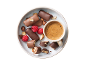 Bonbons au chocolat avec noix et framboises, avec une tasse de café.