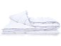 Couette blanche à motif losanges et passepoil bleu, pliée.