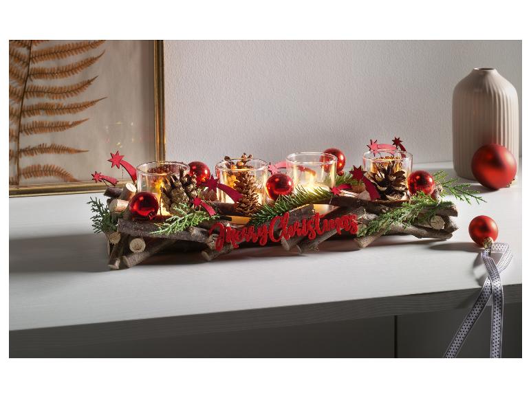 Décoration de Noël avec des bougies dans des pots en verre, des branches, des boules rouges et un panneau 'Merry Christmas'.