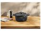 Cocotte en fonte noire sur un comptoir en bois.