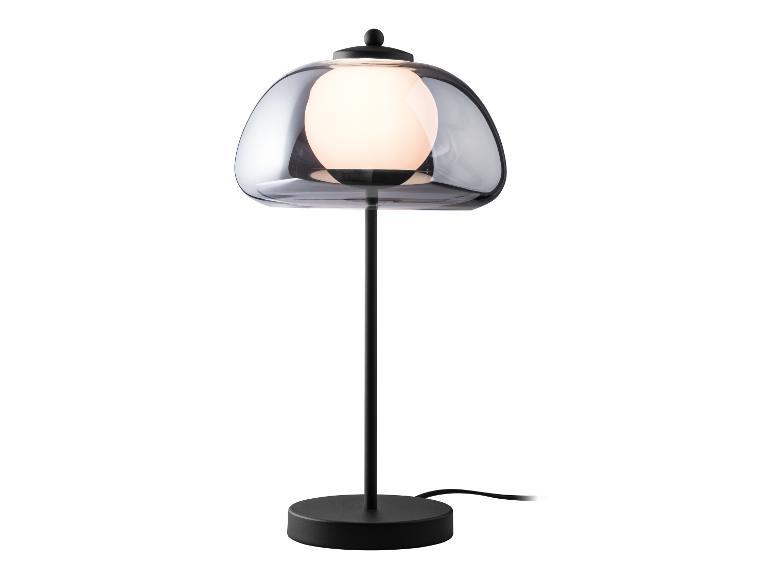 Lampe de table noire avec abat-jour en verre gris.