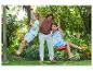 Deux enfants se balancent sur des cordes dans le jardin.