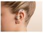 Gros plan de l'oreille d'une personne avec un appareil auditif beige
