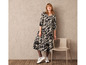 Une mannequin porte une longue robe à imprimé léopard et des baskets blanches.