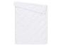 Couverture matelassée blanche avec motif ondulé, pliée sur le dessus.