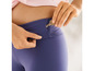Une femme glisse une clé dans la poche de son legging bleu.