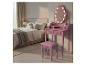 Coiffeuse rose avec miroir lumineux et tabouret dans une chambre à coucher