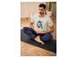 Homme en t-shirt blanc avec l'inscription 'Sweat Recover Repeat' assis sur un tapis de yoga.