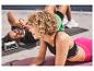 Deux personnes font des exercices avec des supports à push-up et des tapis de yoga Crivit.