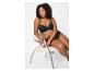 Femme assise sur une chaise en soutien-gorge et culotte noirs.