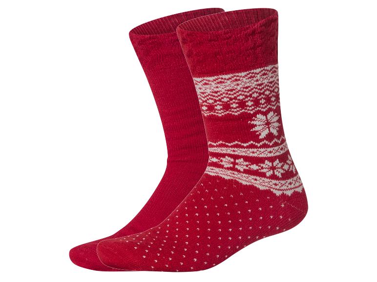 Une paire de chaussettes rouges avec un motif hivernal blanc.