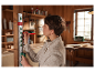 Une femme utilise un niveau Parkside et un crayon dans un atelier pour marquer du bois.