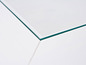 Détail d'une table blanche avec un plateau en verre.