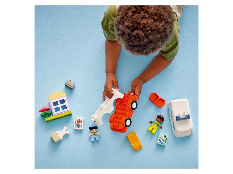 Enfant jouant avec une voiture jouet orange et des blocs de construction colorés.