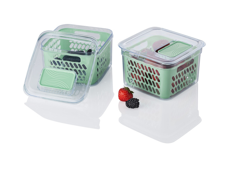 Deux contenants en plastique vert avec des couvercles pour stocker des fruits.
