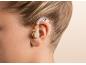 Gros plan de l'oreille d'un enfant avec un appareil auditif beige.