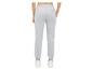 Pantalon de survêtement gris avec des baskets blanches.