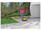 Femme balayant une terrasse avec une balayeuse, avec un vélo et un ballon d'enfant en arrière-plan.