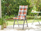 Une chaise pliante avec un coussin à carreaux sur une terrasse.