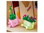 Deux plantes jouets souriantes dans des pots roses et vert clair.