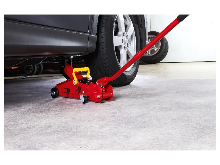 Cric rouge sous une voiture dans un garage