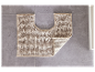 Tapis de bain beige en forme de U sur un sol gris.