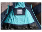 Une veste bleue avec une doublure turquoise et une étiquette pour le nom.
