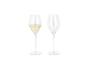 Deux flûtes à champagne, l'une remplie de vin mousseux et l'autre vide, sur fond blanc.