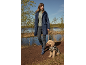 Femme en imperméable bleu foncé et chien en manteau à motifs dans la nature