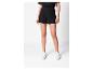 Une femme portant un short noir et des baskets blanches.